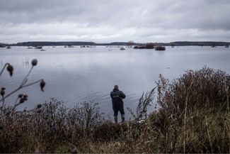 Мужчина рыбачит на реке Ирпень в селе Демидов Киевской области. Часть села до сих пор находится под водой с момента затопления в марте 2022 года