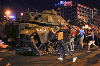 Граждане Турции пытаются остановить танк во время неудачной попытки переворота в столице Турции Анкаре, 16 июля 2016 года