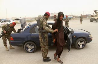 Афганские военные проверяют автомобили после нападения на гарнизон в провинции Балх. 22 апреля 2017 года
