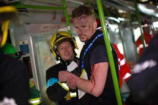 Пожарные выводят волонтера, играющего роль пострадавшего, из вагона метро, 1 марта 2016 года