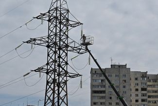 Работник коммунальной службы в Харькове обследует повреждения высоковольтной линии в результате удара со стороны ВС РФ<br>