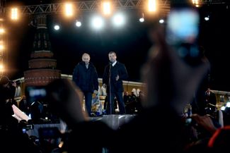 Vladimir Putin and Dmitry Medvedev address a crowd after the former was elected to a third nonconsecutive presidential term on March 4, 2021.