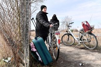 A woman waits in the Hungarian town of Barabás to meet her relatives after they cross the Hungarian-Ukrainian border. February 25, 2022.