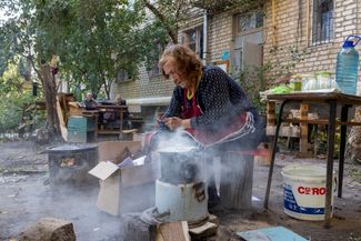 85-летняя жительница Изюма готовит во дворе своего дома