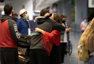 Люди обнимаются в аэропорту Сан-Франциско, 9 ноября 2021 года