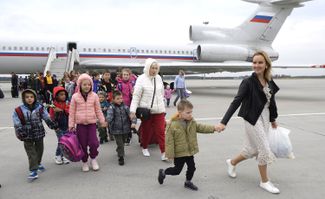 Мария Львова-Белова в аэропорту с детьми-сиротами, вывезенными из аннексированной ДНР в Россию. 16 сентября 2022 года