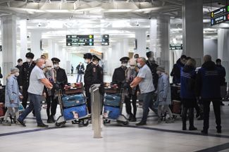 Встреча пассажиров рейса Бангкок — Новосибирск в аэропорту Толмачево. Сотрудники полиции контролируют посадку пассажиров в автобусы для доставки их в обсерватор