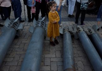 Девочка рассматривает российские ракеты, выставленные на площади у Михайловского собора