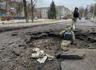 Полиция Краматорска осматривает кратер от ракеты после удара по городу