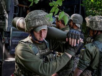 Военнослужащие Украины готовят снаряды для гаубицы недалеко от линии фронта