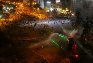 Anti-government protesters in the Chilean capital of Santiago use lasers against riot police. November 1, 2019.