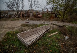 Пустые гробы возле домов в Северске, уничтоженных при обстрелах