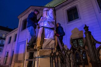 Рабочие накрывают статую, чтобы защитить ее от возможного обстрела. Львов, 3 марта 2022 года