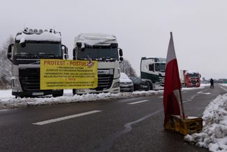 Грузовики с растяжкой польских протестующих возле пограничного перехода Дорогуск-Ягодин, Польша