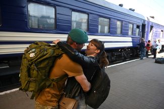 Украинский военнослужащий обнимает жену на железнодорожной станции Львова