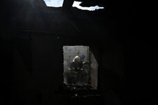Пожарные в жилом доме, попавшем под российский обстрел