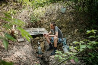 41-летний Артем Черуха набирает воду из источника после того как вода во всем Лисичанске была отключена из-за боев. Этим же источником местные жители пользовались во время Второй мировой войны