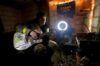 Украинский солдат играет на гитаре рядом с линией фронта в Донецкой области