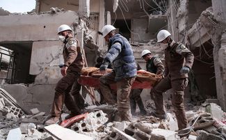 Спасатели из «Белых касок» на развалинах здания после авиаудара в пригороде Дамаска, февраль 2017 года