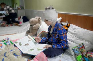 Пятилетний Миша читает книжку в подвале больницы Николаева. При обстреле со стороны российских войск погибла мать Миши, а сам он получил ранение.