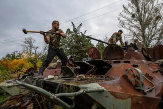Украинские военные демонтируют пушку с захваченного российского БТР рядом с Изюмом