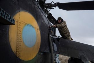 Украинский военнослужащий заправляет боевой вертолет Ми-24