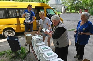 Волонтеры раздают еду жителям района Салтовка. Сейчас в городе нет газа и частично — электричества.