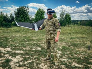 Лейтенант ВСУ держит дрон Parrot во время тренировки в Киевской области. Украинская и российская армии активно используют беспилотные летательные аппараты в войне. 14 июля 2022 года