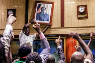 Депутаты снимают со стены парламента портрет президента Зимбабве Роберта Мугабе после его отставки. Хараре, 21 ноября