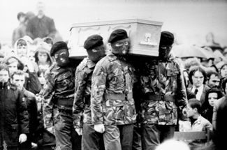 Гроб с телом одного из лидеров Ирландской республиканской армии (ИРА) Бобби Сэндса на похоронах в Белфасте в 1981 году. Сэндс умер в результате 66-дневной голодовки заключенных боевиков ИРА в тюрьме Мейз; после него умерли еще девять заключенных. Они требовали предоставить им статус политзаключенных (и отделить их от прочих преступников). Голодовка ни к чему не привела. Премьер-министр отказалась менять статус заключенных и холодно заметила: «Преступление остается преступлением, потому что это преступление. Политика тут ни при чем». Боевики ИРА боролись за отделение Северной Ирландии от Великобритании и воссоединение этой территории, разделенной между католиками и протестантами, с остальной, преимущественно католической, частью Ирландии