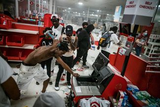 Мародеры — участники массовых беспорядков пытаются вскрыть кассу супермаркета Target. Миннеаполис, штат Миннесота, 27 мая 2020 года
