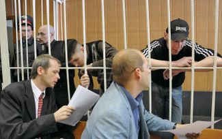 За решеткой, слева направо: Руслан Хубаев, Кирилл Унчук и Игорь Березюк во время заседания Тверского суда.