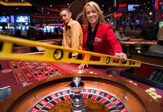 Менеджер Николь Мавроматис измеряет уровень баланса колеса рулетки в казино Maryland Live Casino в Ганновере. 10 декабря 2013 года