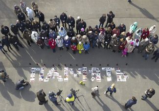 Using photographs of the victims, people spell out the word “REMEMBRANCE” on a street in Kemerovo. March 28, 2018