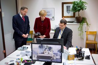 Ангела Меркель посещает штаб-квартиру Федерального ведомства по защите конституции в сопровождении его шефа Ханса Георга Маасена. Кельн, 31 октября 2014 года
