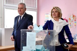 Предыдущий сербский лидер Томислав Николич и его жена голосуют на выборах президента страны в Белграде. 2 апреля 2017 года