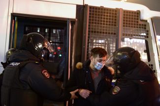 Сотрудники полиции задерживают участника антивоенного протеста в Москве. 26 февраля 2022 года
