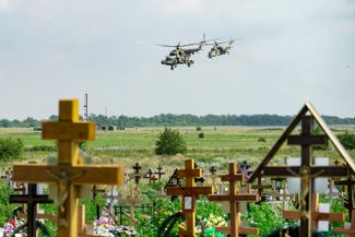 Вертолеты с буквой Z на борту летят над кладбищем в Ростовской области на границе с Украиной. Недалеко от этого места находится военный аэродром Таганрог-Центральный<br>