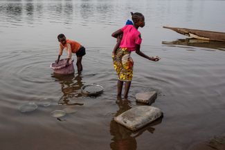 Дети мою посуду в водах реки Обангуи в столице ЦАР — городе Банги