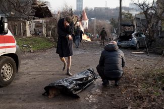 Житель Киева плачет возле тела своей жены, погибшей во время обстрела