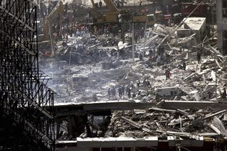Спасатели и пожарные ищут людей под развалинами небоскребов. В результате терактов 11 сентября погибли более 400 работников спасательных служб