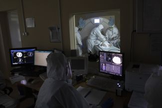 Осман Османов и его коллега Виталий Мушкин готовят пациента с коронавирусом к компьютерной томографии. 15 мая 2020 года