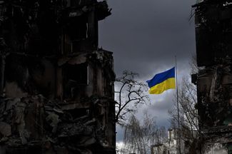 Украинский флаг на фоне разрушенных зданий в Бородянке, Киевская область