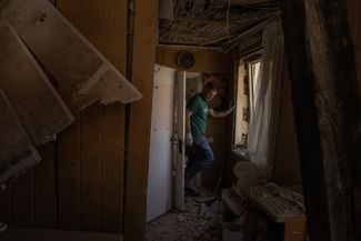 Киевлянин идет по дому своей матери, серьезно пострадавшему в результате российского обстрела