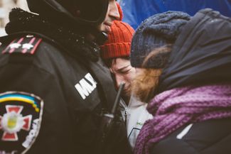 Участница протестов уговаривает сотрудника милиции не разгонять протестующих на Майдане Незалежности. 9 декабря 2013 года.