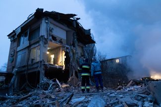 Сотрудники МЧС самопровозглашенной ДНР возле одного из разрушенных во время обстрела зданий в Донецке