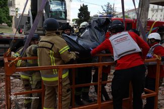 Сотрудники ГСЧС переносят тело погибшего жителя Днепра
