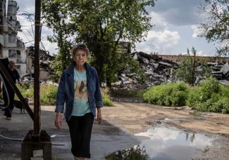 Жительница Угледара на фоне разрушений, которые принесла в город война
