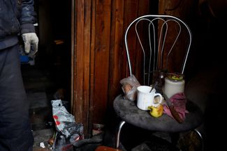 Михаил Юрков в своем доме, куда он вернулся после шести месяцев в бункере. При обстрелах дом сильно пострадал, поэтому Михаил вынужден использовать стул в качестве обеденного стола