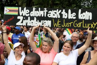 На плакате написано: «Нас не спрашивали, когда мы родились в Зимбабве, нам просто повезло»